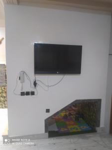 a flat screen tv hanging on a white wall at Duplex pour famille seulement in Fez