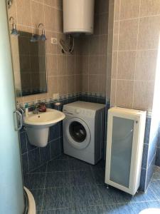 a bathroom with a washing machine and a sink at Pandora's Seaview Apartment in Durrës