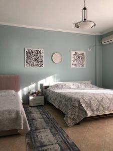 a bedroom with two beds and a rug at Pandora's Seaview Apartment in Durrës
