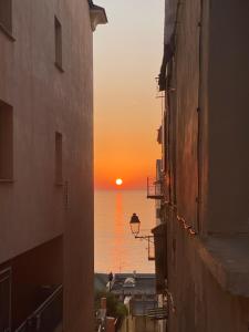 a view of the ocean from an alley way at sunset at Centre historique bastia in Bastia