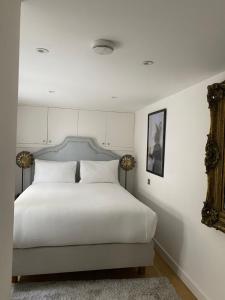 a bedroom with a large white bed and a mirror at Salt Life Contemporary Apartment in Brighton & Hove