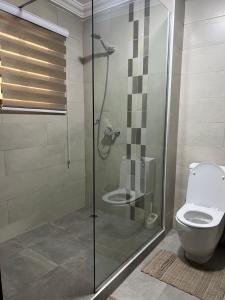 a bathroom with a shower and a toilet at Nuben Court-Accra in Accra