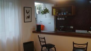 um bar com duas cadeiras e um balcão num quarto em Departamento en Palermo em Buenos Aires