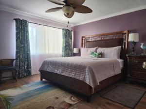 a bedroom with a large bed with a ceiling fan at Old Town Suites in Key West