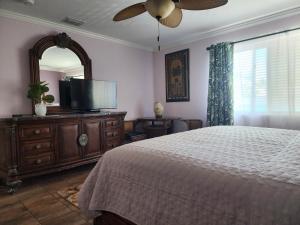 um quarto com uma cama, um espelho e uma televisão em Old Town Suites em Key West