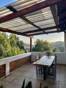 een houten tafel en stoelen op een balkon met uitzicht bij Herradura VIP Inn in Mazamitla