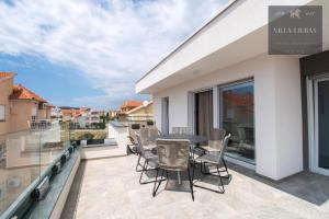 een patio met een tafel en stoelen op een balkon bij VILLA LJUBAS in Srima