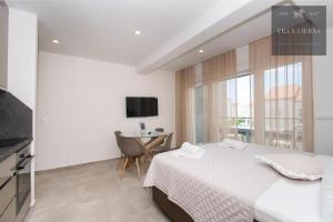 a bedroom with a bed and a table and a television at VILLA LJUBAS in Srima