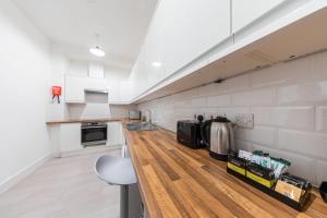 a kitchen with white walls and a wooden floor at Charming Hotel with Kitchen & Laundry near Tufnell Park in London