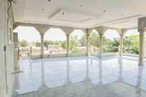 an empty house with a large porch with columns at Le Doux Refuge in Djérigbé