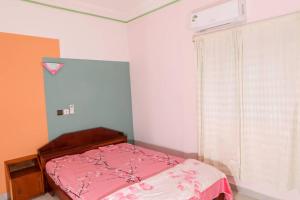 1 dormitorio con cama rosa y ventana en Le Doux Refuge, en Djérigbé