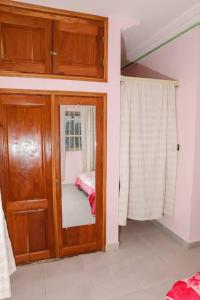 a room with a door with a mirror and a bed at Le Doux Refuge in Djérigbé