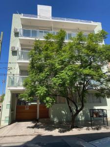 un árbol frente a un edificio con garaje en SANTA ROSA en Córdoba