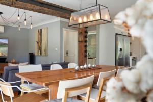 Delamarele في Medlow Bath: غرفة طعام وغرفة معيشة مع طاولة وكراسي خشبية