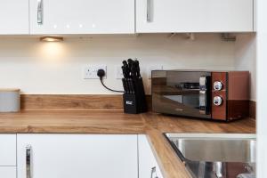 a kitchen with a toaster oven on a counter at Superb 3BR House in Coventry Sleeps 9 w/Parking in Canley