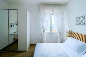 Habitación blanca con cama y ventana en Hotel Premuda, en Spotorno