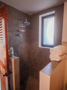 ein Badezimmer mit einem Fenster und einem Haufen Handtücher in der Unterkunft Casa Pelicano in Puerto Escondido