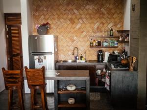 eine Küche mit einem Kühlschrank sowie einem Tisch und Stühlen in der Unterkunft Casa Pelicano in Puerto Escondido
