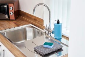 a kitchen sink with a soap dispenser on it at Superb 3BR House in Coventry Sleeps 9 w/Parking in Canley