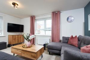 uma sala de estar com um sofá e uma televisão em Superb 3BR House in Coventry Sleeps 9 w/Parking em Canley