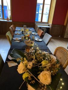 een lange tafel met een blauwe tafeldoek en bloemen erop bij Casa Bella in Charroux-dʼAllier