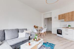 a living room with a gray couch and a table at Modern, bright and spacious apartment in Prague