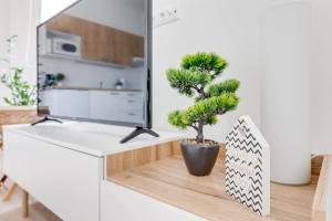 a potted tree sitting on a white desk in a living room at Modern, bright and spacious apartment in Prague