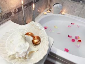 a bath tub filled with pink hearts and candles at Albina apartman in Eger