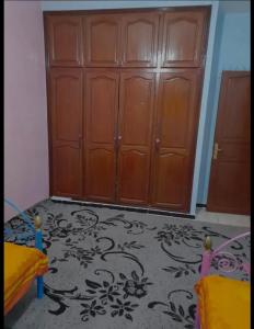 Zimmer mit einem Holzschrank und einer Tür in der Unterkunft Narjis hay ryad fes in Fès