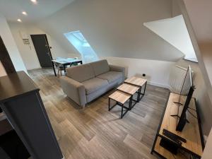 ein Wohnzimmer mit einem Sofa und einem Tisch in der Unterkunft LE VIEUX LAVAL in Laval