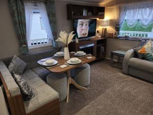 a living room with a table and a couch at Rosie's Seton Retreat in Port Seton