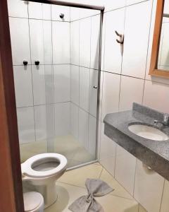 y baño con ducha, aseo y lavamanos. en Santa Catarina Hotel, en Aparecida