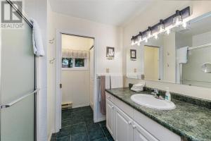 a bathroom with a sink and a mirror at Salty Towers Ocean Front Cottages in Sooke