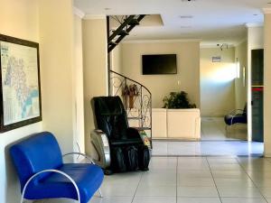 una habitación con sillas y equipaje en el suelo en Santa Catarina Hotel, en Aparecida
