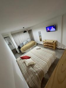 een hotelkamer met 2 bedden en een televisie bij Departamento monoambiente Barrio Martin in Rosario