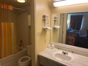 Un baño con lavabo, inodoro y espejo. en Lebanon Inn Motel, en Lebanon