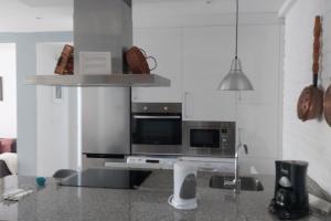 a kitchen with a microwave and a stove top oven at Fabuloso piso a estrenar en el centro de Santiago in Santiago de Compostela +11 photos