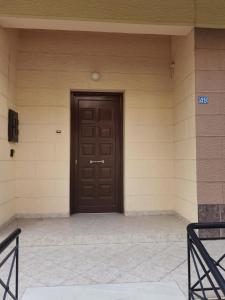 una puerta marrón en el lateral de un edificio en Silence area 1 in north Athens, en Acarnas