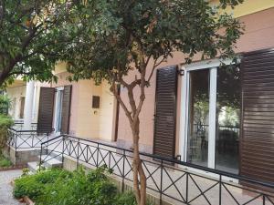 a building with black shuttered windows and a tree at Silence area 1 in north Athens in Acharnes