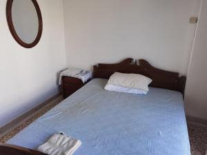 1 dormitorio con cama azul y espejo en Silence area 1 in north Athens, en Acarnas