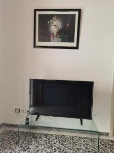 TV de pantalla plana sobre una mesa de cristal en Silence area 1 in north Athens, en Acarnas