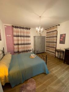 - une chambre avec un lit et un lustre dans l'établissement Oca Carolina, à Buttigliera Alta