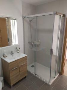 een badkamer met een glazen douche en een wastafel bij Vivienda turística Ca Lola in Vilafames