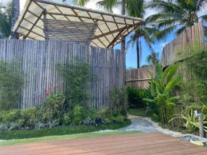 a garden with a wooden fence and a wooden walkway at Woody's Place Siargao in General Luna