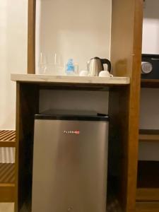 a small refrigerator under a counter in a kitchen at Woody's Place Siargao in General Luna