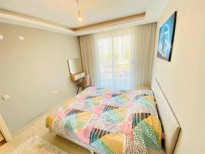 una camera da letto con un letto con un piumone colorato di Antalya Konyaaltı Liman A5- Denize Yakın a Antalya (Adalia)