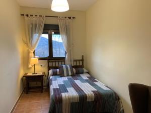 - une petite chambre avec un lit et une fenêtre dans l'établissement Casa Rural Fuentecillas, à Becedas