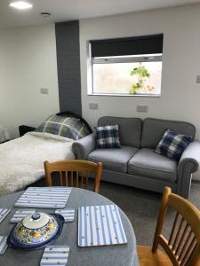 a living room with a couch and a table at Annexe in lymington with private use of hot tub in Everton
