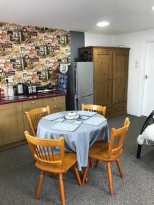a kitchen with a table with chairs and a refrigerator at Annexe in lymington with private use of hot tub in Everton
