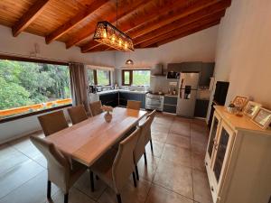 a kitchen and dining room with a wooden table and chairs at El Shaddai Casa de Montaña in Lago Puelo